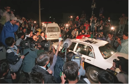 マスコミに囲まれる被疑者